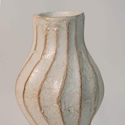 Close up of wavy ceramic vase highlighting smooth glaze texture and elegant hand-carved contours.