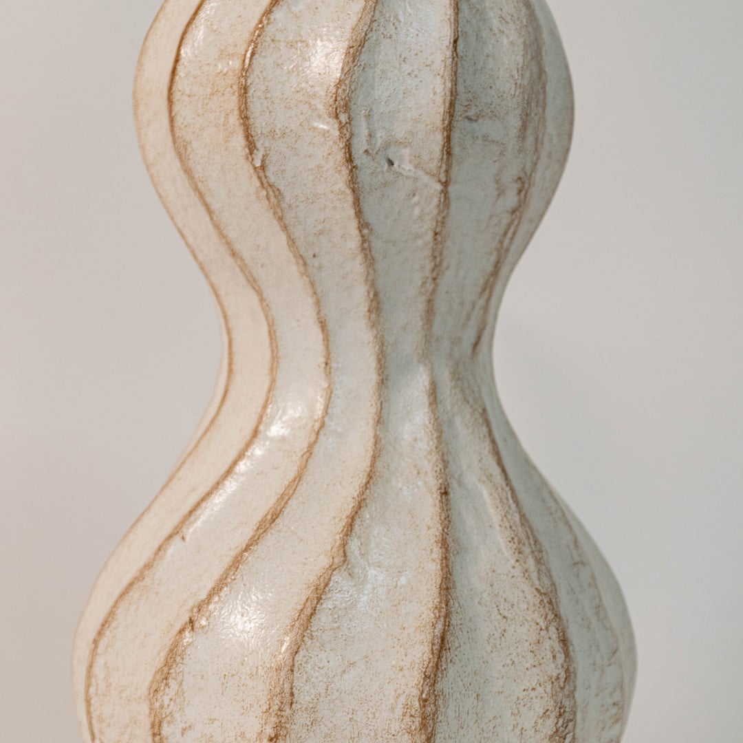 Detailed view of wavy ceramic vase showing the fine vertical ridges soft glaze and handcrafted pottery detail.