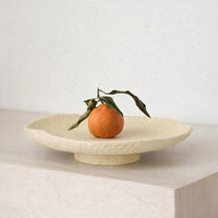 Beige ceramic decorative platter placed on marble table for elegant modern tabletop and dining decor styling.