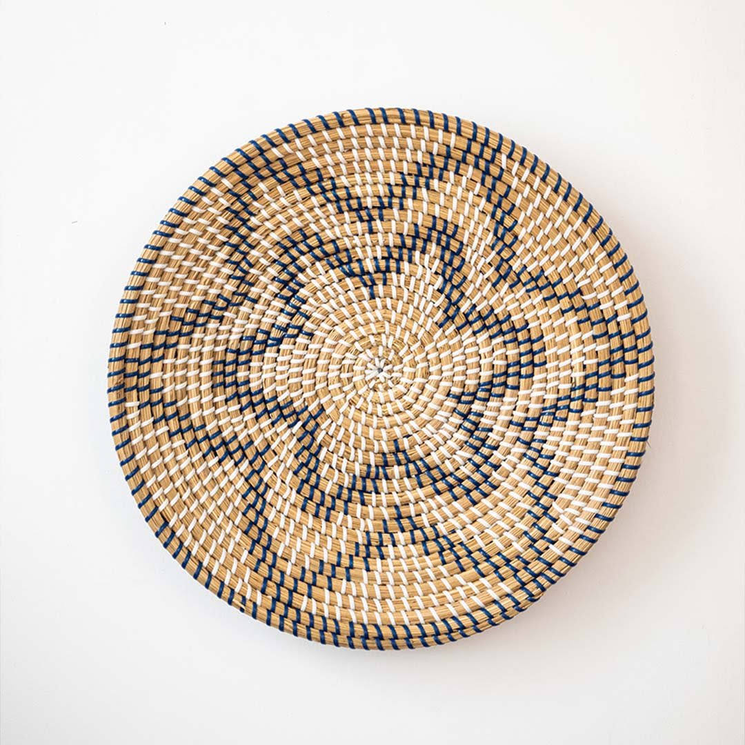Beautiful star geometric patterned black and beige woven seagrass wall basket plate decoration isolated on white.