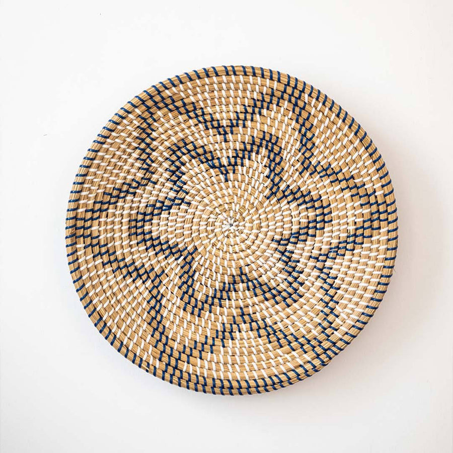 Beautiful star geometric patterned black and beige woven seagrass wall basket plate decoration isolated on white.