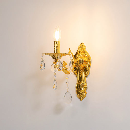 Luxury gold metal crystal wall light glowing warmly on white background for classic bedroom and hallway decor.