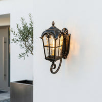 Traditional black metal outdoor wall lantern for porch entrance patio and exterior walls with warm ambient lighting.