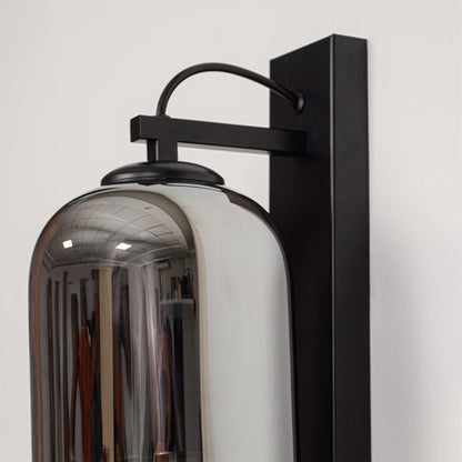 Contemporary black metal wall light with smoked glass shade and sleek industrial frame for interiors.