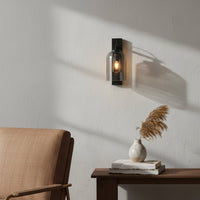 Modern black metal wall light enhancing cozy bedroom corner with warm ambient interior lighting decor.