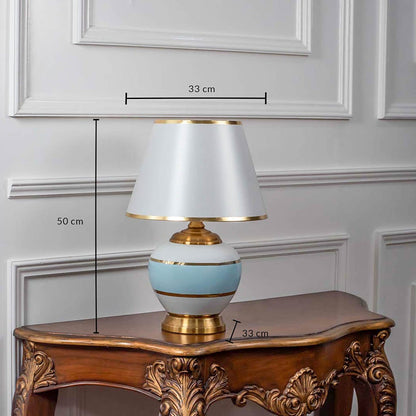 Designer ceramic and metal table lamp measuring 50 cm in height and 33 cm in width featuring a modern blue and white body with gold accents.