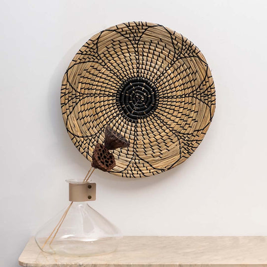 Handwoven wicker basket wall decor styled with minimal vase for rustic and boho inspired interiors and modern wall decoration.