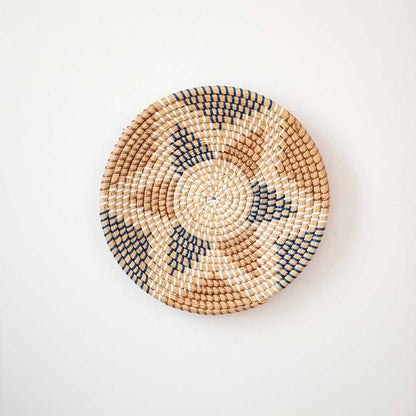 Aztec star geometric patterned black and beige woven seagrass wall hanging basket plate decoration isolated on white.
