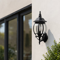 Black metal outdoor wall lantern with clear glass for porch entrance garden and exterior walls with elegant warm lighting.