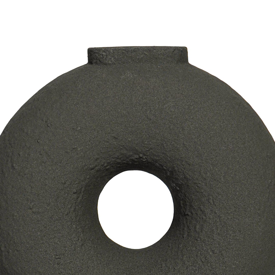 Close view of black ceramic ring vase highlighting textured matte finish circular form and sculptural modern design.