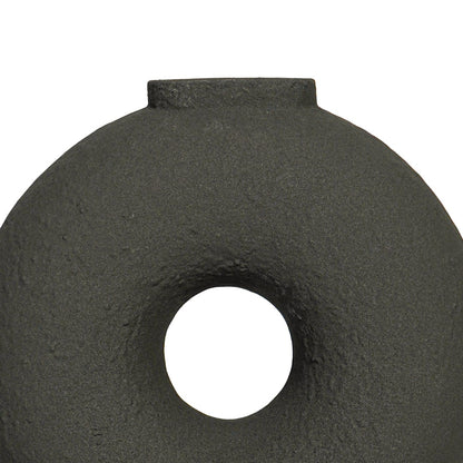 Close view of black ceramic ring vase highlighting textured matte finish circular form and sculptural modern design.