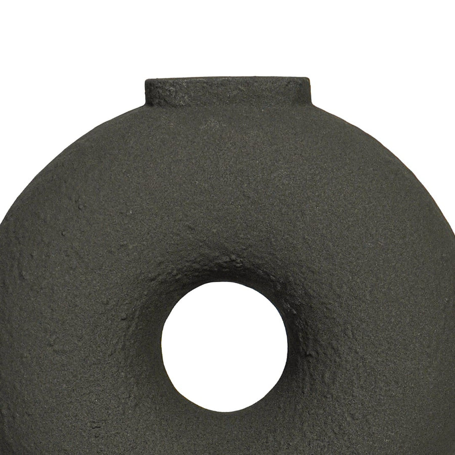 Close view of black ceramic ring vase highlighting textured matte finish circular form and sculptural modern design.
