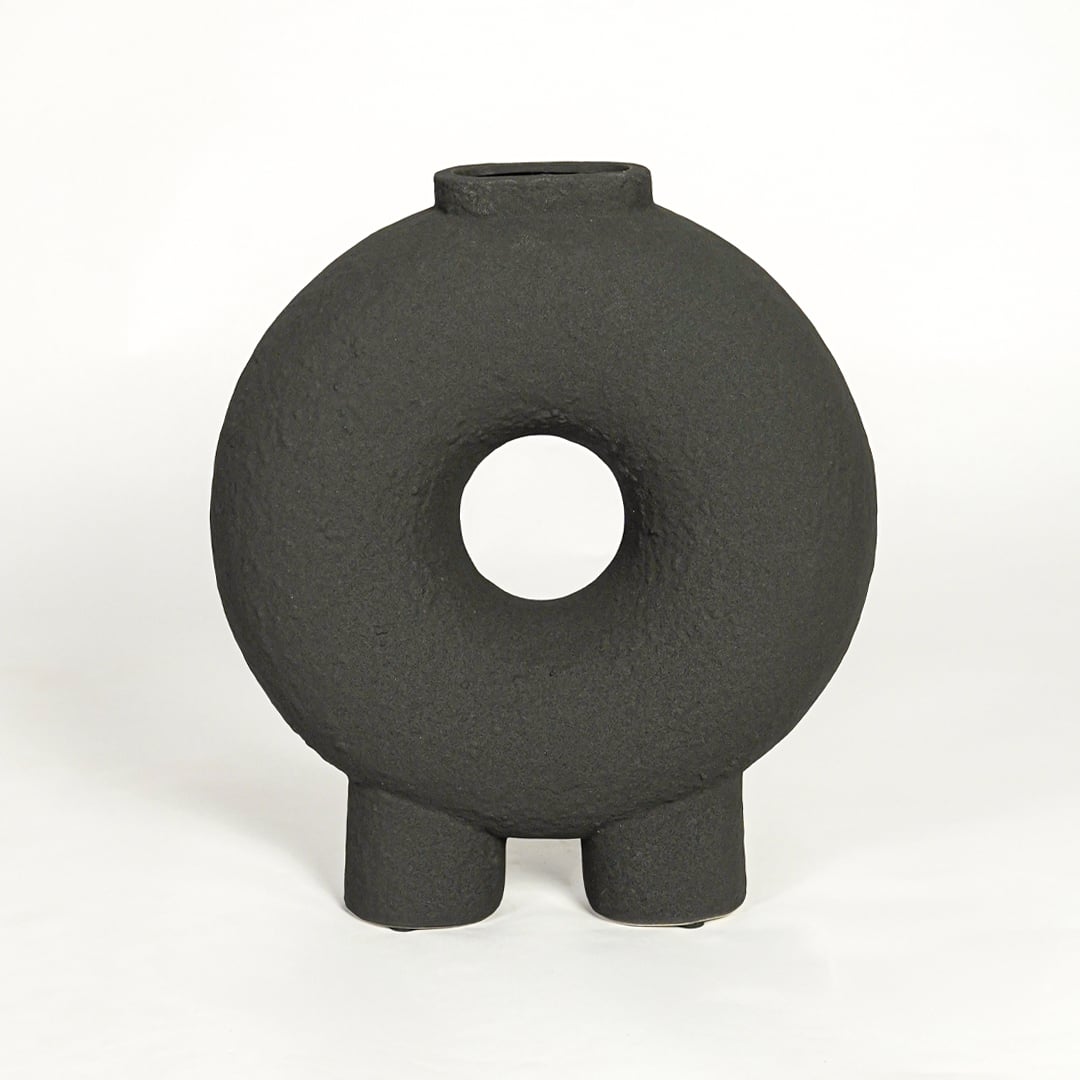 Modern black ceramic statement donut vase with hollow center for coffee table console or shelf styling.