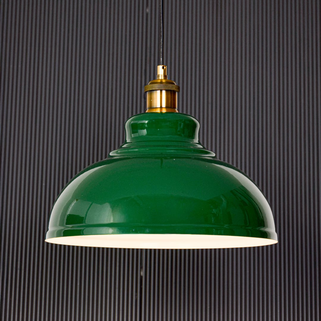 Green metal pendant ceiling light displayed on black background highlighting glossy dome shade gold holder and clean modern design.