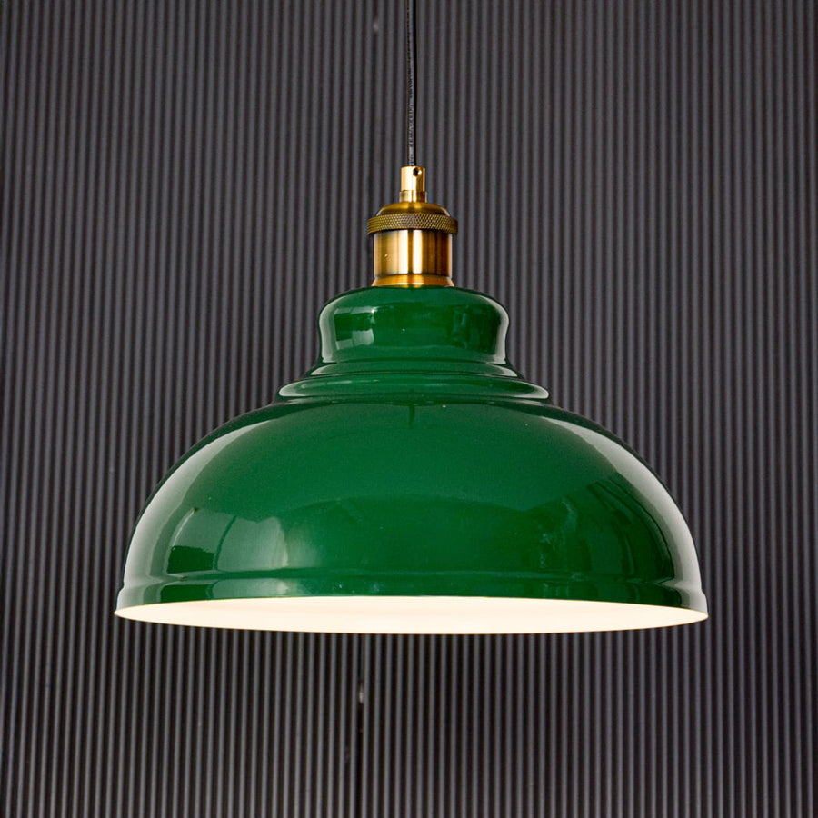Green metal pendant ceiling light displayed on black background highlighting glossy dome shade gold holder and clean modern design.