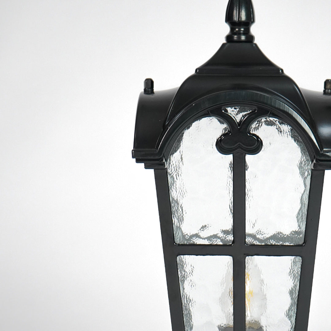 Closeup of vintage black outdoor gate light with textured glass panels for elegant exterior decor styling.