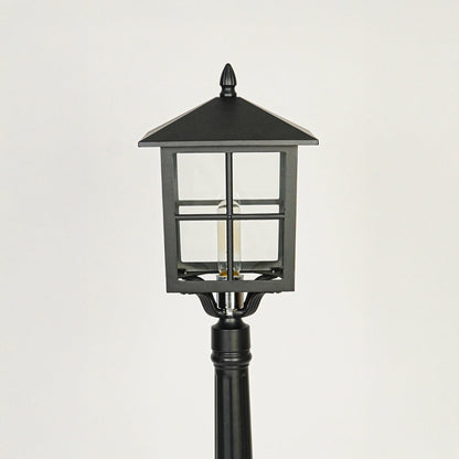 Close view of black outdoor lamp post with glass enclosure showcasing durable weather resistant exterior lighting design.