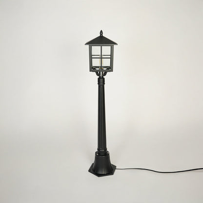 Minimal outdoor pole light with traditional lantern style and black metal body on clean background ideal for garden or patio lighting.