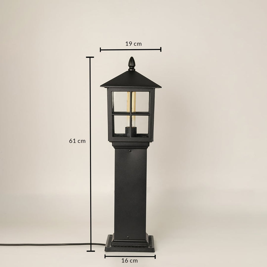 Outdoor garden pillar lamp with black metal body and glass panels showing 62 cm height and 18 cm base width for exterior placement.