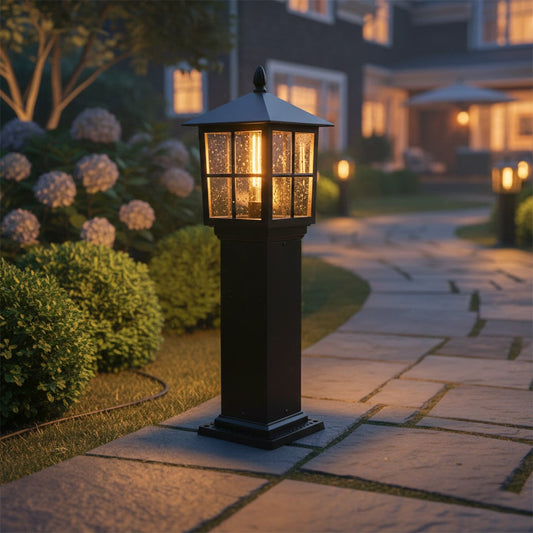 Classic outdoor post lamp in black metal with glass shade placed beside pathway adding warm glow and refined curb appeal at night.
