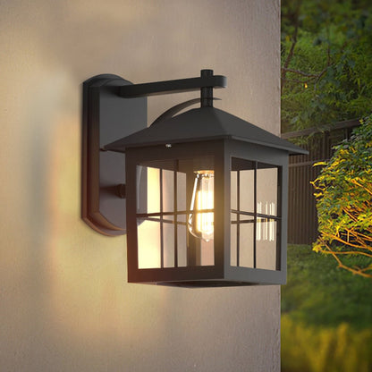 Modern outdoor wall light with black frame and glass panels glowing warmly on exterior wall for stylish home lighting.