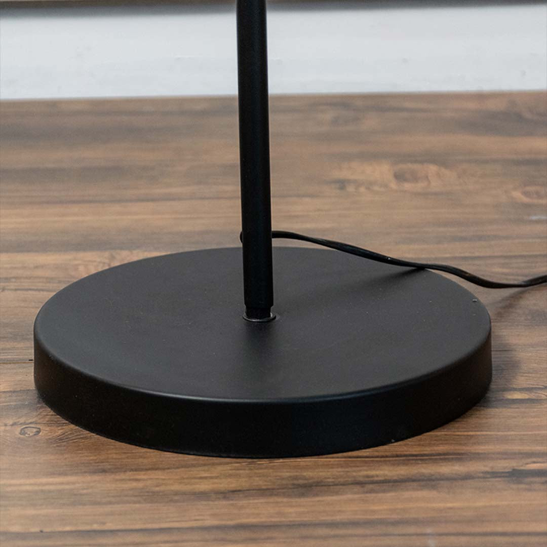 Black metal floor lamp base with slim stem and white fabric shade highlighting modern minimalist elegance.