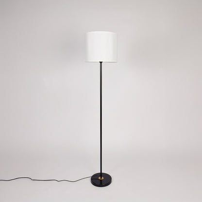 Black metal floor lamp with white fabric drum shade designed for modern living room bedroom and reading nook decor.