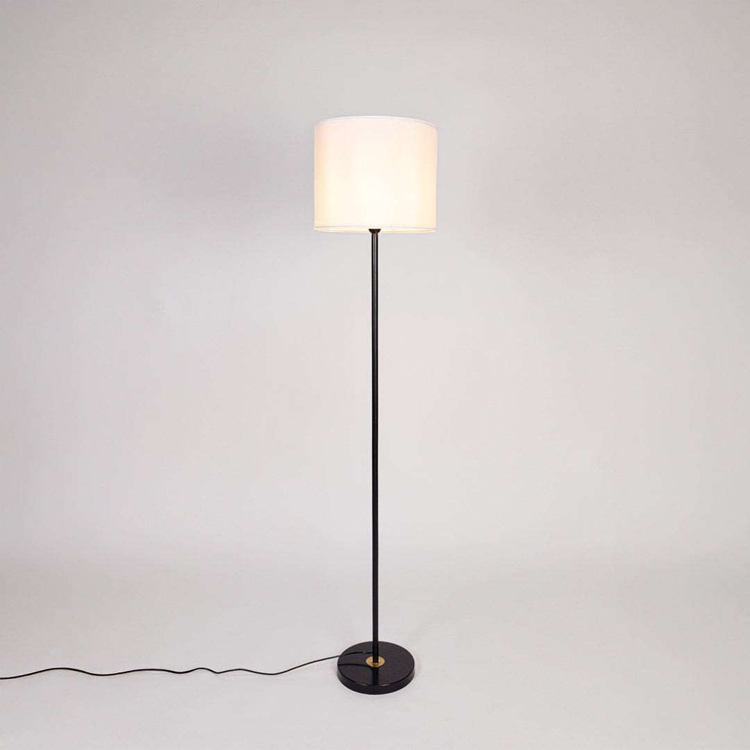 Black metal floor lamp with white fabric drum shade designed for elegant living room and bedroom lighting decor.