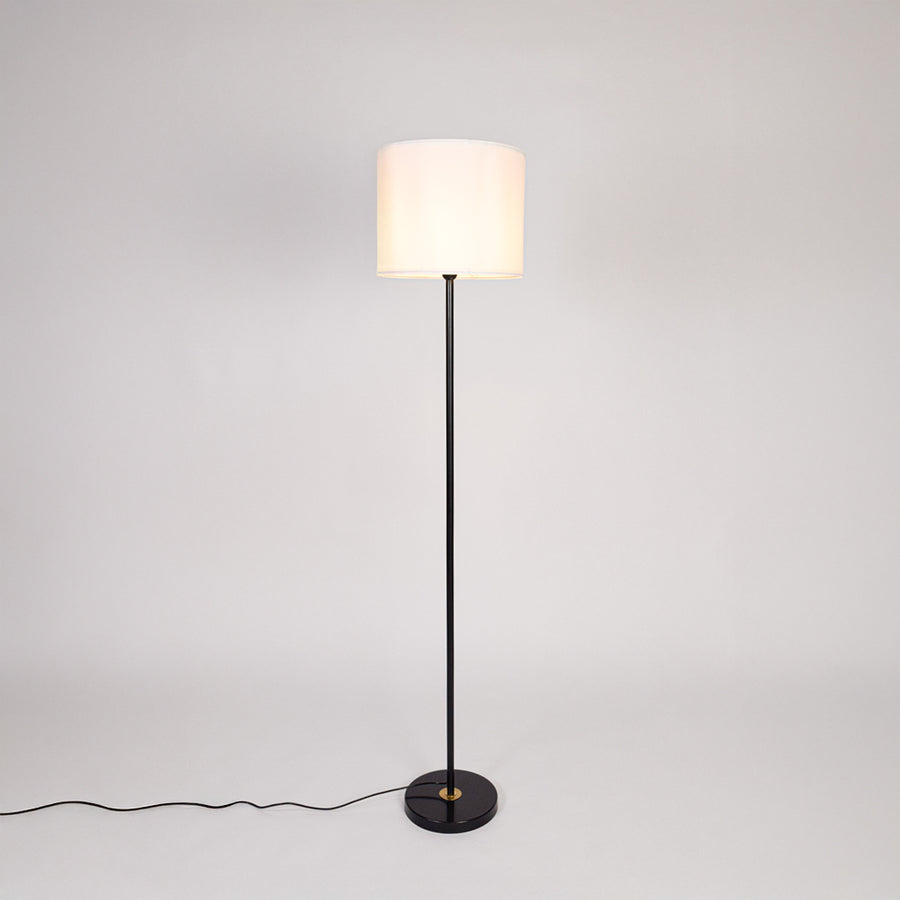 Black metal floor lamp with white fabric drum shade designed for elegant living room and bedroom lighting decor.
