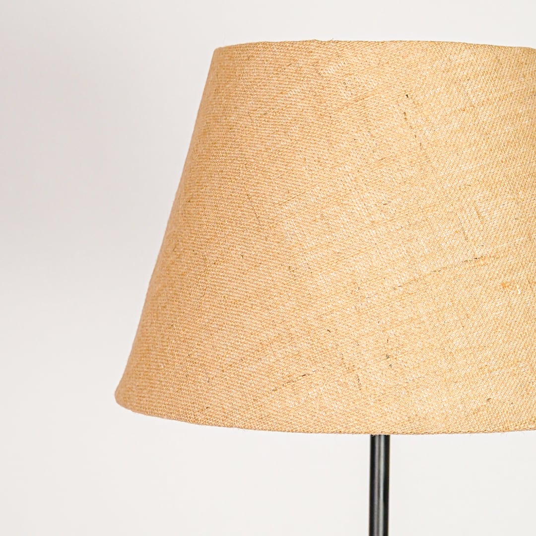 Tapered beige linen fabric lampshade designed to softly diffuse light for cozy warm interior ambiance.