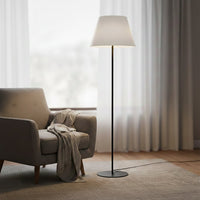 Modern black metal floor lamp with white fabric shade placed in living room corner for soft ambient lighting Decor.