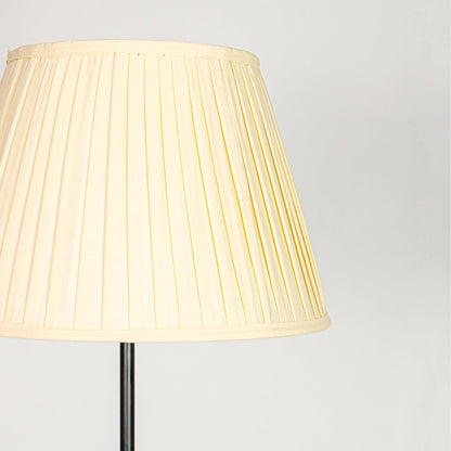 Wide pleated cream fabric lampshade with soft tapered silhouette designed to diffuse warm and cozy light evenly.