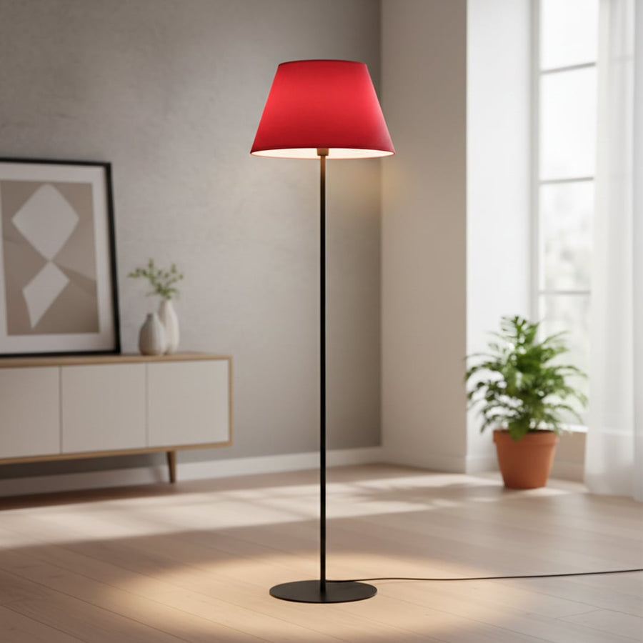 Modern black metal floor lamp with red tapered shade styled in contemporary living room corner setup.