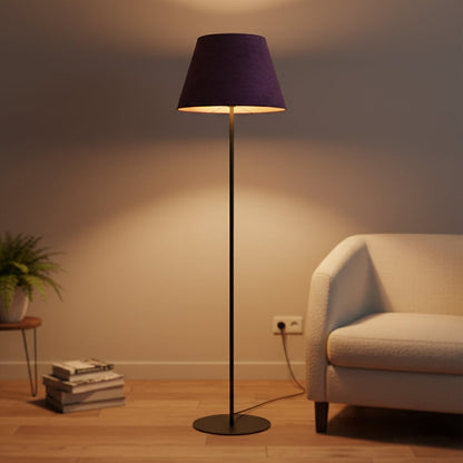 Modern black metal floor lamp with rich purple fabric shade styled in contemporary living room interior setting.