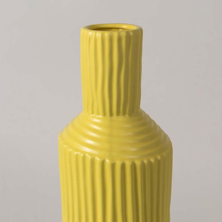Closeup of yellow ribbed ceramic vase showing its textured finish and glossy surface ideal for modern stylish home decorating.