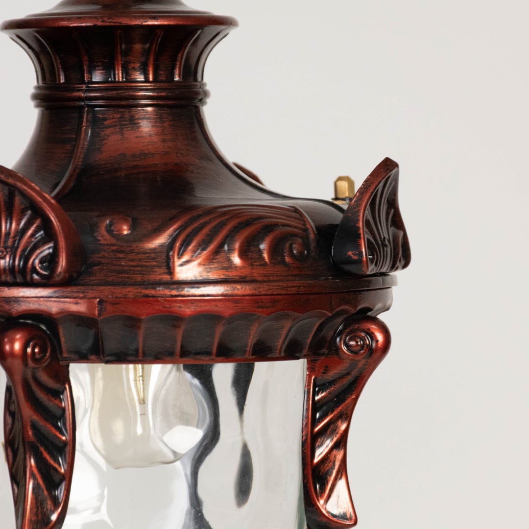 Traditional hanging lantern light glowing warmly on white background showing detailed frame and clear glass.