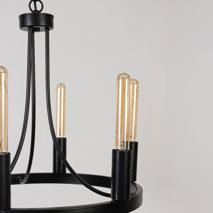 Detailed closeup of exposed vintage Edison tube bulb with black metal candle holder socket on contemporary chandelier fixture.