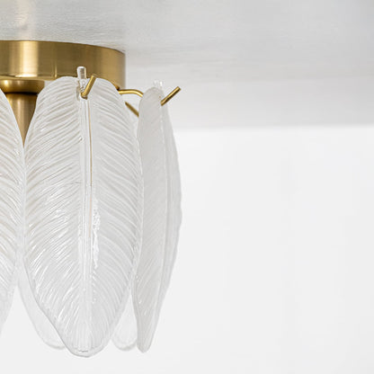 Closeup of gold ceiling light featuring frosted sculpted leaf glass panels designed to add elegant decorative texture and soft ambient lighting.