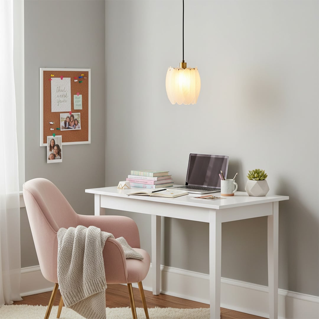 Pendant light hanging above a white study desk with soft seating and decor creating a calm modern workspace atmosphere.
