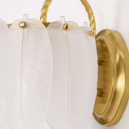 Clear textured glass wall light closeup with polished gold metal backplate and fittings highlighting premium craftsmanship and finish.
