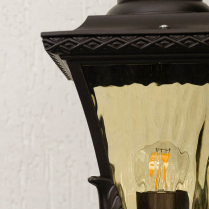 Zoom view of decorative outdoor pillar lantern in black metal with patterned glass shade for timeless garden lighting.