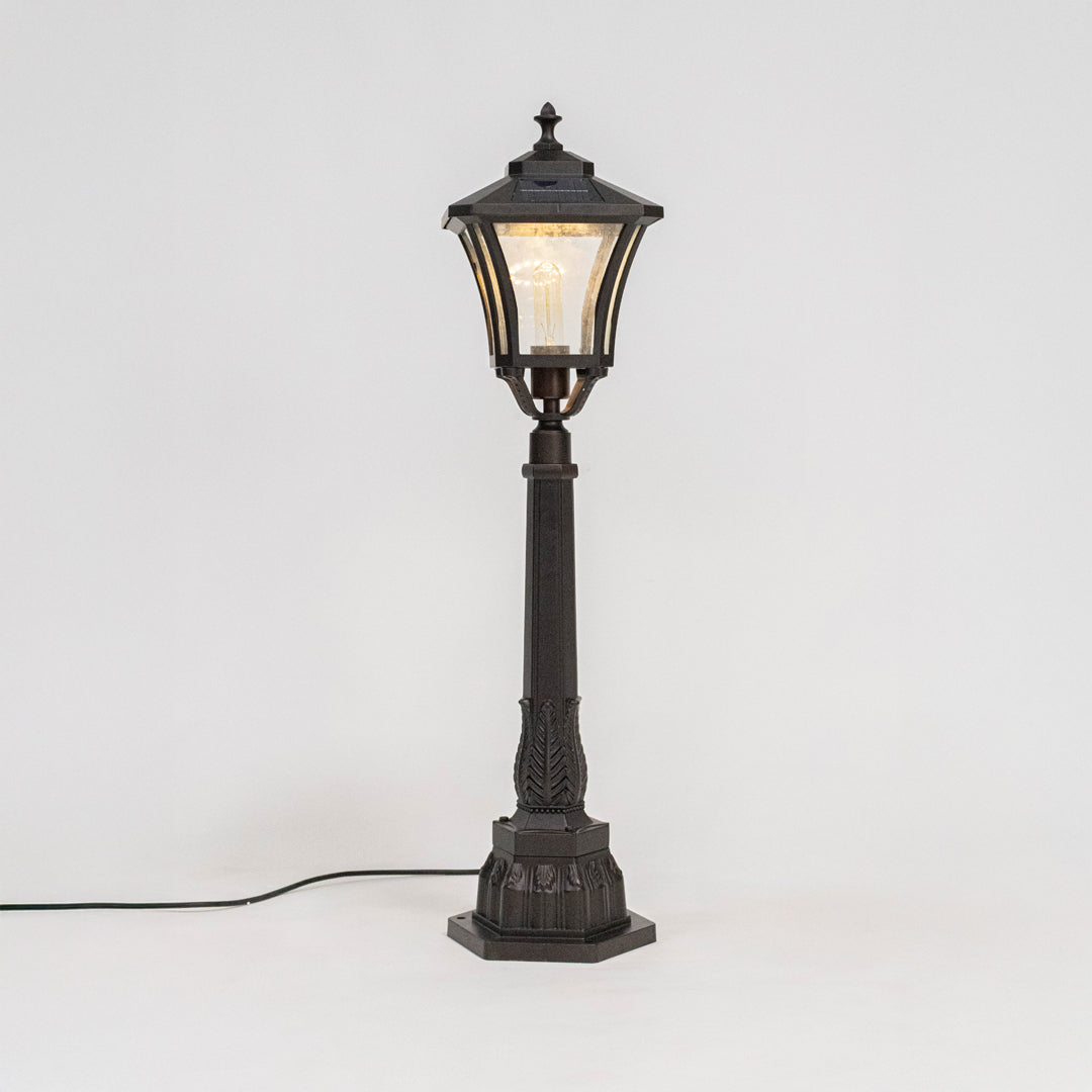 Antique black outdoor street lamp with glowing lantern panels for luxury exterior decor use.