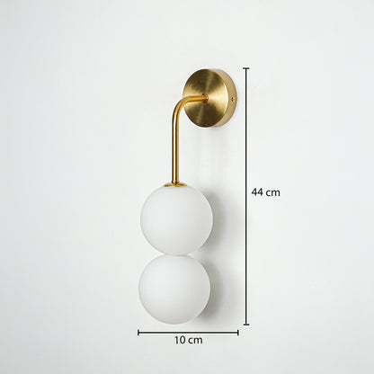 Gold wall light with double frosted glass globes on white background with dimensions modern vertical lighting ideal for bedroom decor.