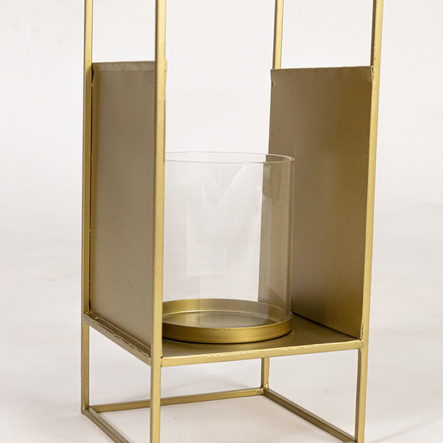 Closeup of gold metal lantern base highlighting clear glass holder smooth metallic finish and elegant decorative styling.