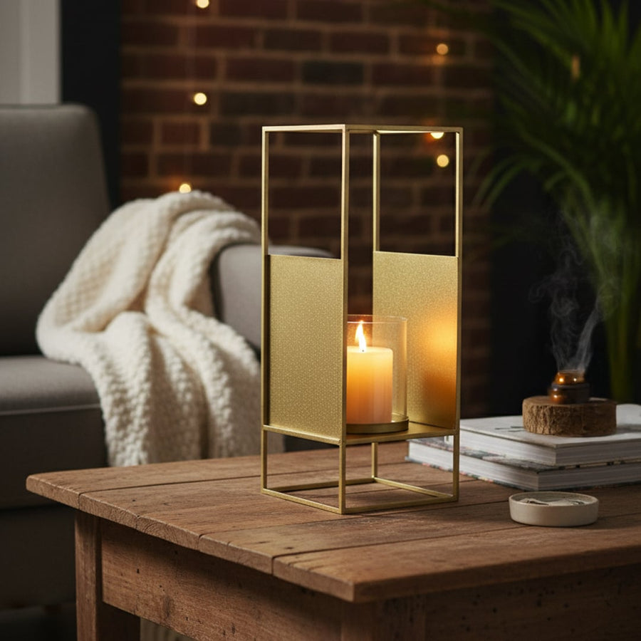 Gold metal decorative lantern with clear glass candle holder styled on console table adding warm ambient glow to modern home Decor.