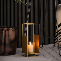 Modern gold metal geometric candle lantern for outdoor patio floor decking balcony area and contemporary home decor display.
