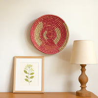 Round floral wall decor plate in rich color displayed above console adding vibrant artistic contrast and refined handcrafted character to living space.