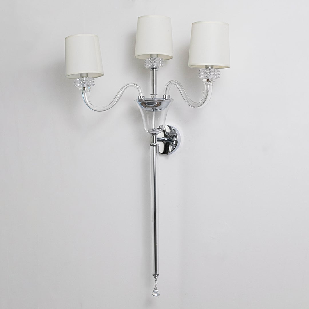 Triple arm wall light with chrome base and fabric shades turned off on white background for wall decor.