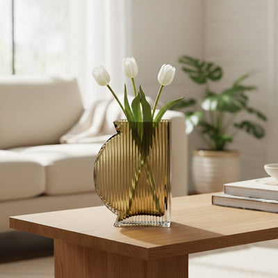 Amber glass decorative vase styled with white flowers on a wooden table for elegant contemporary home decor settings.