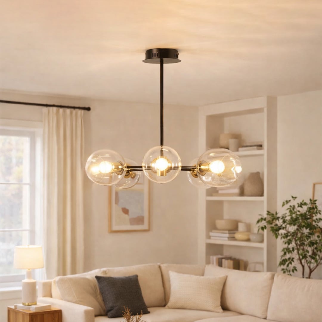 Blue tinted glass chandelier above sofa seating creating warm ambient lighting for modern living room interiors.